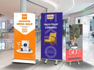 Phân vân giữa standee cuốn nhôm và chữ X? So sánh chi tiết về giá, độ bền, thẩm mỹ để chọn đúng loại standee quảng cáo cho sự kiện của bạn.