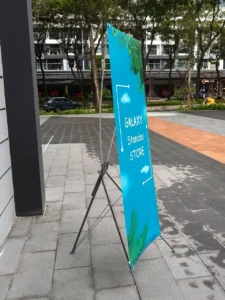 Standee chữ X với khung chân chữ X chắc chắn, thiết kế gọn nhẹ, dễ lắp đặt và phù hợp trưng bày quảng cáo tại cửa hàng, sự kiện